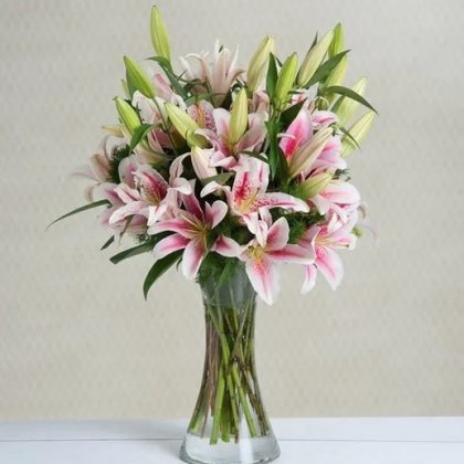 Hermosos lirios en florero de vidrio